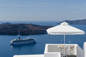 a white boat sitting on top of a white beach at Kamares Apartments in Fira