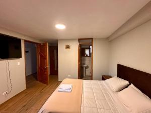 a bedroom with a large bed and a television at Casa SAMAY OLLANTAYTAMBO in Ollantaytambo