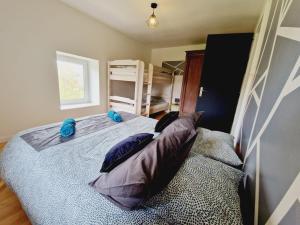 ein Schlafzimmer mit einem Bett mit Kissen darauf in der Unterkunft Le Petit Hangy in Fresse-sur-Moselle