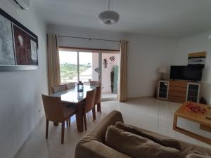 sala de estar con mesa y sofá en 4AH Brisa Mar - Casas & Papéis, en Armação de Pêra