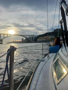 a couple on a boat in the water with a bridge at Navegar no Douro - Navegação e Turismo Unipessoal, Lda in Vila Nova de Gaia