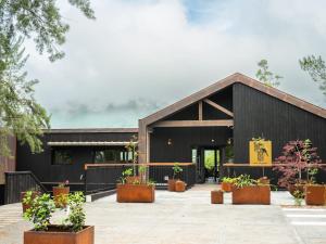 un edificio negro con macetas delante de él en Hôtel le Tuit-Tuit, en La Plaine-des-Palmistes