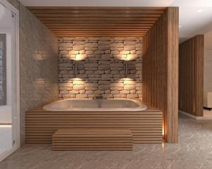 a bath tub in a room with a stone wall at RENEX HOTELS in Antalya
