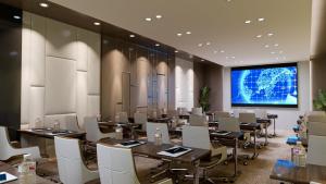 a conference room with tables and chairs and a projection screen at RENEX HOTELS in Antalya