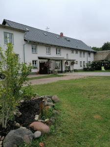 una gran casa blanca con un jardín delante de ella en "Märkische Traube" idyllisches Gästehaus für Selbsversorger, en Zesch