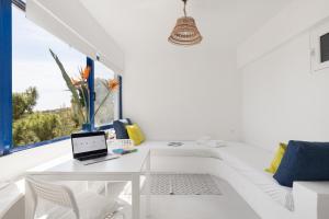 een witte kamer met een bureau en een laptop. bij Renovated Seaside Cabin in Sounio in Sounio