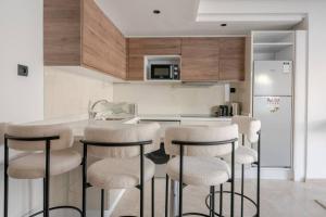 a kitchen with a counter and stools in a room at TT Holidays Cosy Apartment/ Casablanca City in Casablanca