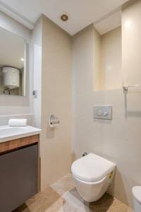 a white bathroom with a toilet and a sink at TT Holidays Cosy Apartment/ Casablanca City in Casablanca