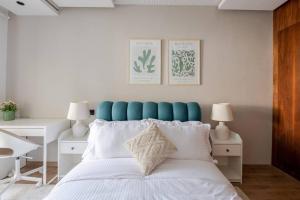 Schlafzimmer mit einem großen Bett mit blauem Kopfteil in der Unterkunft TT Holidays Cosy Apartment/ Casablanca City in Casablanca