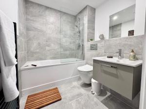 een badkamer met een bad, een toilet en een wastafel bij Apartment 27 city gate York in York