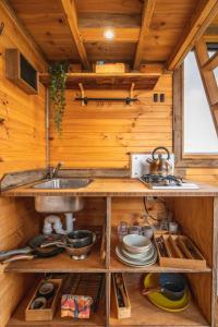 a kitchen with a sink and a stove at Altitude - A Tiny House Experience in a Goat Farm in Romsey