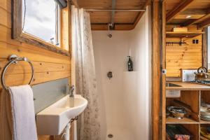 a bathroom with a sink and a window at Altitude - A Tiny House Experience in a Goat Farm in Romsey