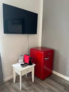 a red refrigerator next to a small table with a tv at Villa Garden Island in Berlin