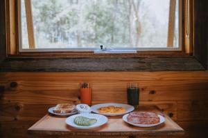 una mesa con platos de comida encima de una ventana en Rendezvous Nexus en Toolangi