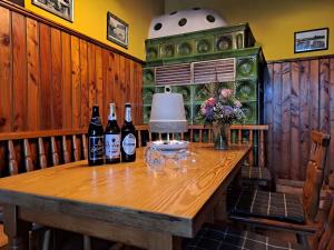 Landpension Bielatal - Raum في Raum: طاولة عليها زجاجات من النبيذ والزهور