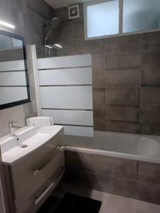 een badkamer met een wastafel en een bad bij Appartement proche PARIS/STADE DE FRANCE in Épinay-sur-Seine