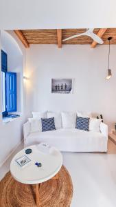 a white living room with a white couch and a table at Chiara Mykonos in Mýkonos City