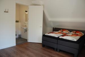 a bedroom with a bed and a bathroom at Vakantiehuis B&B Familie Versantvoort in Handel