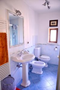 een badkamer met een wastafel, een toilet en een spiegel bij Rifugio al mare della Versilia in Strettoia
