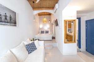 a living room with a white couch and a bed at Chiara Mykonos in Mýkonos City