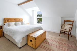 a bedroom with a bed and a chair and a window at Apartment in the heart of Beer on Jurassic Coast in Beer