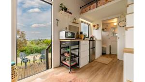 a tiny house with a kitchen and a balcony at Wodalla Horse Farmstay in Nyora