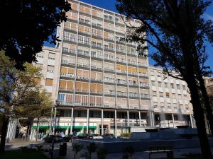 a large building with cars parked in front of it at IRIS Bilocale Centro Città in Busto Arsizio