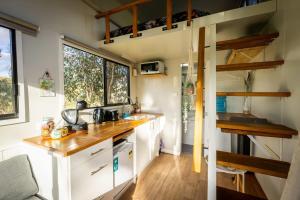 uma cozinha numa pequena casa com um balcão em Tiny House Farmstay at Dreams Alpaca Farm - A Windeyer Outback Experience em Windeyer