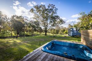 Windeyer的住宿－Tiny House Farmstay at Dreams Alpaca Farm - A Windeyer Outback Experience，庭院旁甲板上的热水浴池
