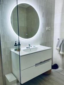 bagno con lavandino bianco e specchio di CASA MIRABEL a Villaverde
