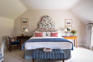 a bedroom with a large bed with a large headboard at Ballymaloe House Hotel in Ballycotton