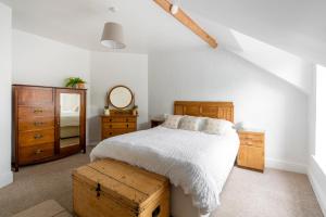 a bedroom with a bed and a dresser and a mirror at Apartment in the heart of Beer on Jurassic Coast in Beer