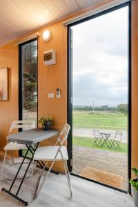 tavolo e sedie in una stanza con una grande finestra di Tiny House Big View a Boneo