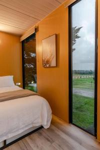 - une chambre avec un lit et une grande fenêtre dans l'établissement Tiny House Big View, à Boneo