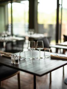 tres copas de vino sentadas en una mesa de madera en Hôtel le Tuit-Tuit, en La Plaine-des-Palmistes