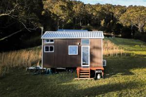 une petite maison brune assise dans un champ dans l'établissement Little Magic on Magic Mountain, à Coolangatta