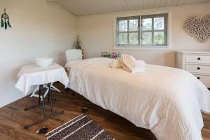 Un dormitorio con una gran cama blanca y una ventana en Little Magic on Magic Mountain en Coolangatta