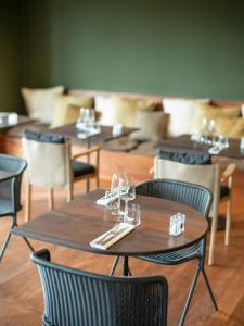 una fila de mesas y sillas con copas de vino. en Hôtel le Tuit-Tuit, en La Plaine-des-Palmistes
