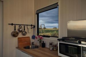 cocina con fregadero y ventana en Farm Tiny, en Braidwood