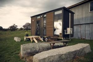 a tiny house with a picnic table in a field at Farm Tiny in Braidwood