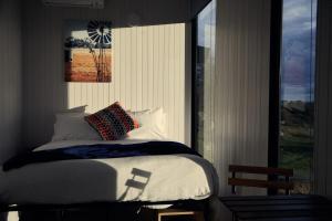 a bedroom with a bed and a picture of a windmill at Farm Tiny in Braidwood