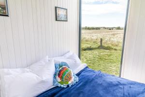 a bed with a pillow on it with a window at Tiny Balloon House in Canowindra