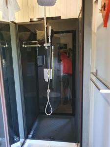 a shower in a room with a glass door at Tiny Balloon House in Canowindra
