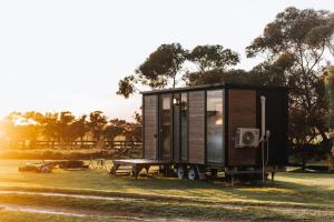 a tiny house on wheels parked in a field at Bush Retreat in Alberton West