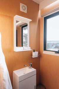 La salle de bains est pourvue d'un lavabo et d'un miroir. dans l'établissement Bush Retreat, à Alberton West