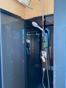 a shower in a bathroom with a man in the mirror at Bush Retreat in Alberton West