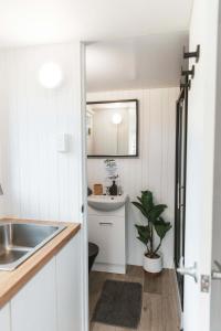 una piccola cucina bianca con lavandino e servizi igienici di Kookaburra Cabin a Palmwoods