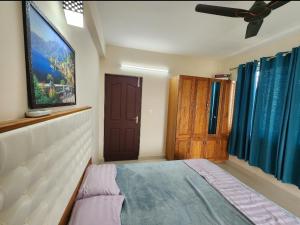 a bedroom with a bed and a window and a door at Sharon Holidays Near LULU in Trivandrum
