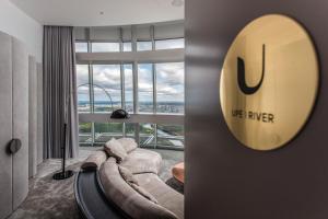 a living room with a couch and a large window at Vilnius TV Tower Apartments DEBESYS in Vilnius