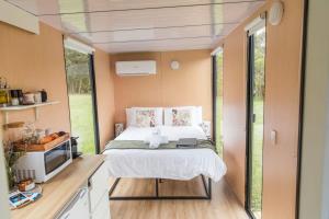 a small bedroom with a bed and a tv at Gumnut in Kangaroo Valley
